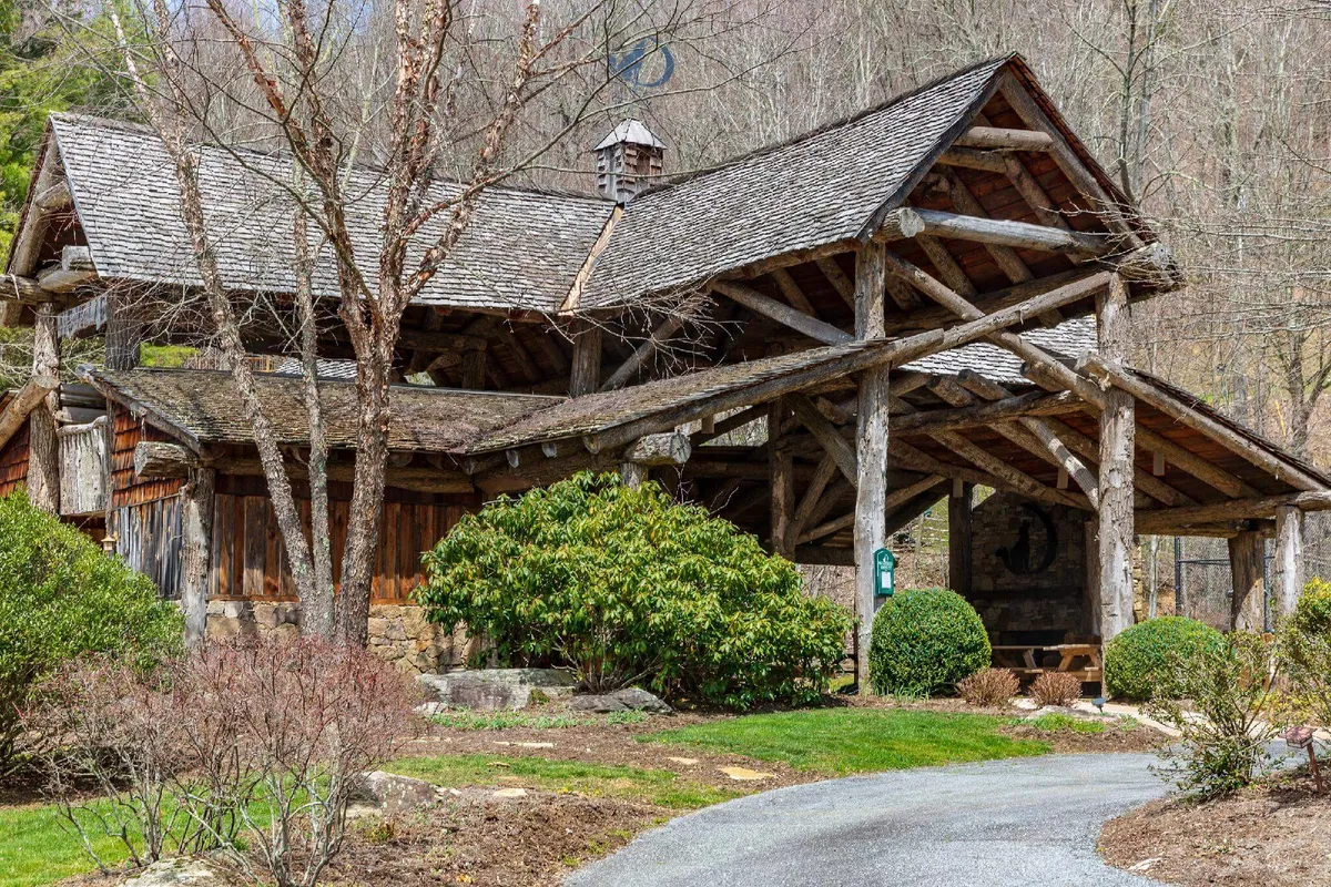 This image features a charming wooden structure set amidst a landscaped garden, with a winding stone pathway and lush greenery. The inviting porch area hints at peaceful mornings or tranquil evenings spent close to nature, seamlessly blending the shelter of the cabin with the beauty of its forest surroundings.